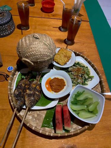 a tray of food on a table with plates of food at The Alam Bungalow & Restaurant in Tetebatu