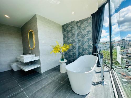 a bathroom with a tub and a large window at Memory Inn - Valley View in Xuan An