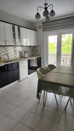 a kitchen with white cabinets and a table and chairs at Arya home 18 in Trabzon