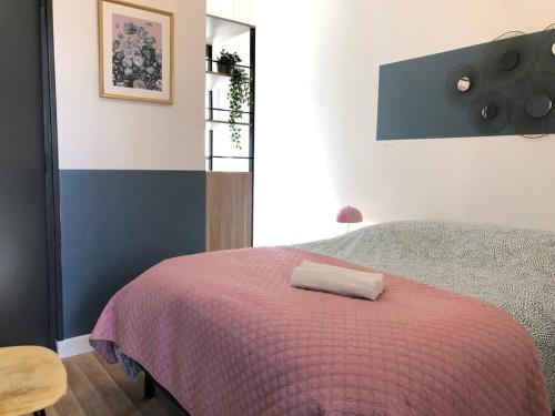 - une chambre avec un lit et une couverture rose dans l'établissement Studio Armorique - commerces, à Brest