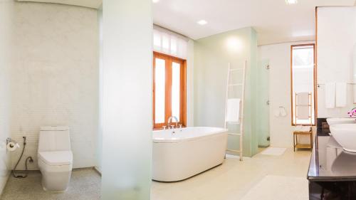 a bathroom with a tub and a toilet and a sink at 6BR Rawai Seaside Villa Swimming Pool in Ban Saiyuan (1)