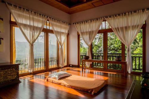 1 dormitorio con 1 cama en una habitación con ventanas grandes en 6BR Rawai Seaside Villa Swimming Pool en Ban Saiyuan (1)