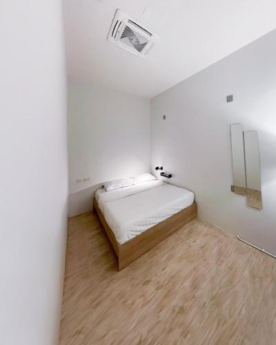 a small white room with a bed in it at Paknap Hostel in Nan