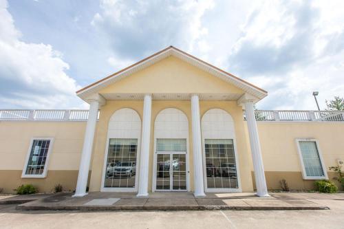 a large building with pillars in front of it at Savannah House Hotel in Branson