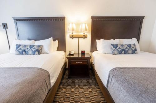 a hotel room with two beds and a night stand at Savannah House Hotel in Branson