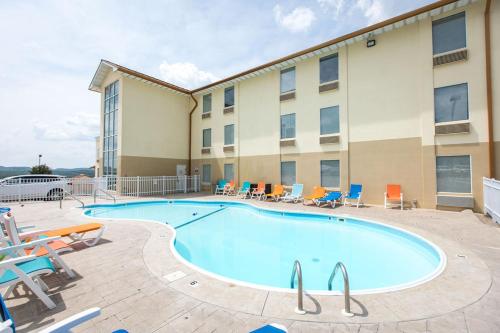a pool at a hotel with chairs and a building at Savannah House Hotel in Branson