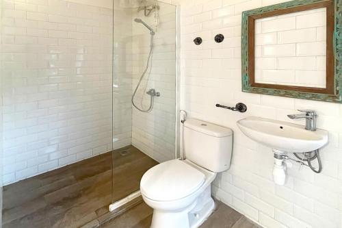 y baño con aseo, lavabo y ducha. en Urbanview Wisma Nirwana Tretes by RedDoorz en Pasuruan