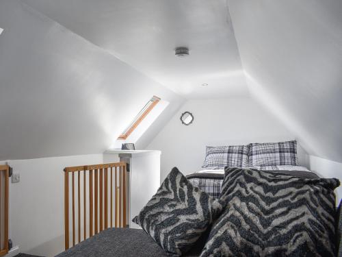 a bedroom with a bed and a sloped ceiling at The Hobbit in Inverallochy