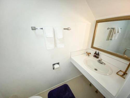 uma casa de banho branca com um lavatório e um espelho em Fairway View em Sisters