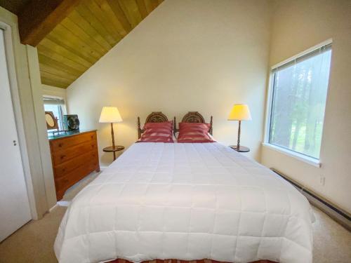 um quarto com uma grande cama branca com almofadas vermelhas em Fairway View em Sisters