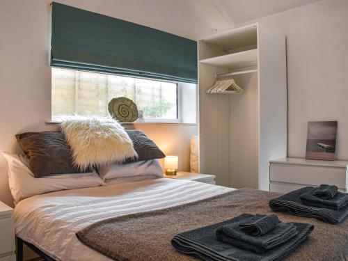een slaapkamer met een bed met twee handdoeken erop bij Ty Cwtch in Nottage