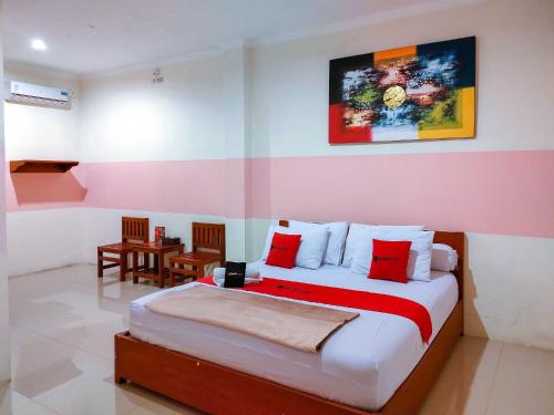 ein Schlafzimmer mit einem Bett und einem Tisch darin in der Unterkunft RedDoorz Near Jalan Jendral Sudirman in Manado