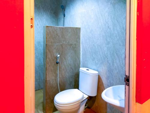 a bathroom with a toilet and a sink at RedDoorz Near Jalan Jendral Sudirman in Manado