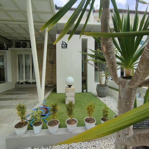 un patio con palmeras y plantas en un edificio en Kayana Regency F7 en Batu