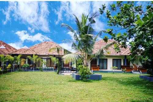 a house with a lawn in front of it at KOTTACKAL NATURE INN in Nedumbassery