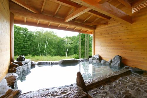 a swimming pool in a wooden house with a window at バートンホテル Barton Hotel in Shinano