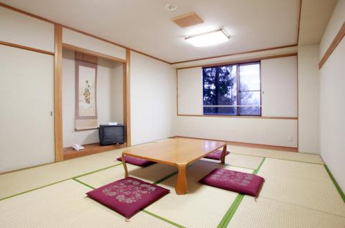 a room with a table and a tv in it at バートンホテル Barton Hotel in Shinano
