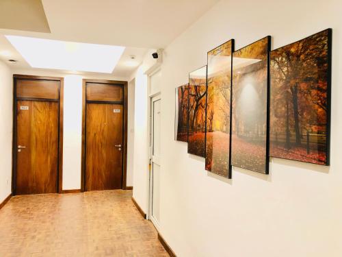 a hallway with four paintings on the wall at Tropic Inn - Mount Lavinia in Mount Lavinia