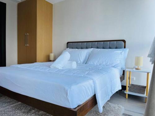 a bedroom with a large bed with white sheets at Luxurious Minimalist1BR Uptown Parksuites Tower 1 in Manila