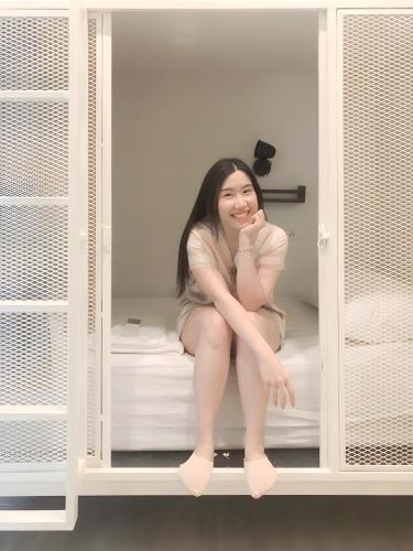a girl is sitting on a bed in a cabinet at Paknap Hostel in Nan