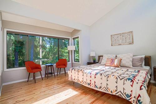 sypialnia z łóżkiem, stołem i krzesłami w obiekcie Sunlit contemporary Bellevue Home w a Lush Garden w mieście Bellevue