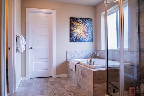 a bathroom with a tub and a shower and a sink at Kirkland Luxury Tranquil Retreat 7BR w Office in Kirkland