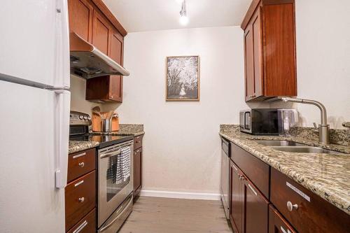 a kitchen with wooden cabinets and a white refrigerator at Bellevue's townhome btw T-mobile & Microsoft HQ in Bellevue