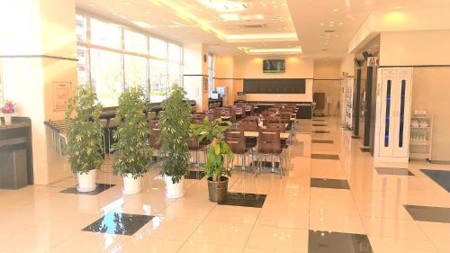 uma sala de conferências com mesas e vasos de plantas num edifício em Toyoko Inn Urawa misono eki Higashi guchi em Saitama