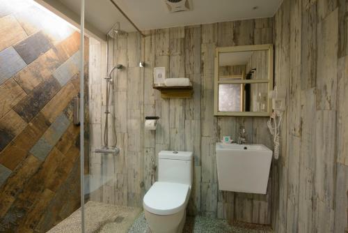a bathroom with a toilet and a shower at Hualien Wow Hostel in Hualien City
