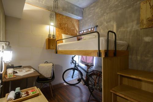 花蓮市的住宿－花蓮洄瀾窩青年旅舍，一间设有双层床的房间和一辆自行车