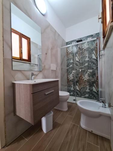 a bathroom with a sink and a tub and a toilet at casa al mare kalispera in Marina di Mancaversa