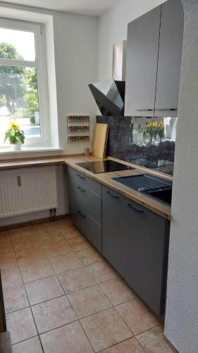 a kitchen with a stove and a window in it at Ferienwohnung am Hofladen Hellendorf - Sächsische Schweiz in Bad Gottleuba