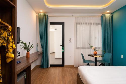 a hotel room with a bed and a table and a window at Hoianese Sunset Serenity Hotel in Hoi An