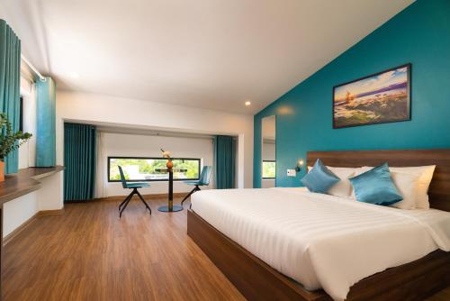 a bedroom with a large bed and a desk at Hoianese Sunset Serenity Hotel in Hoi An