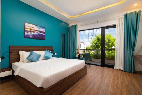a bedroom with a large bed with blue walls at Hoianese Hotel - Lip Lip Pool Villa in Hoi An