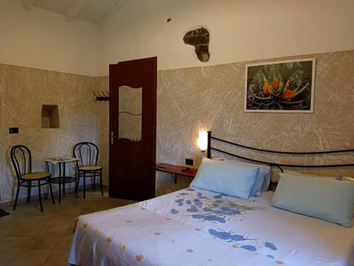 1 dormitorio con 1 cama, mesa y sillas en Terra Del Bosco Agriturismo, en Sesta Godano