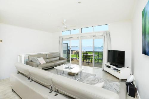 a living room with a couch and a tv at Wonderful Central Location Sea Views in Victor Harbor