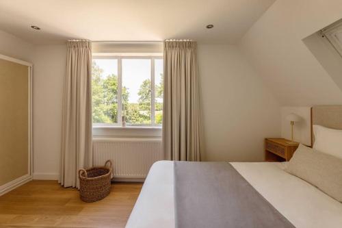 Un dormitorio con una cama grande y una ventana en Stylish villa 12p with private pool in the Veluwe en Garderen