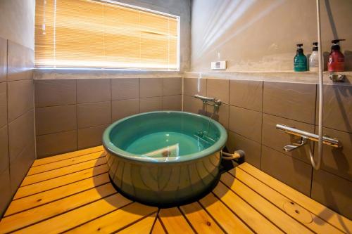 a large tub in a bathroom with a window at 千葉地域ランキング1位獲得の贅沢な貸別荘全4棟 