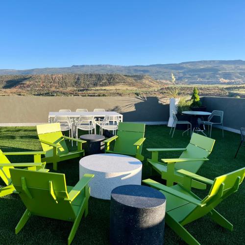 a patio with green and yellow chairs and tables at Skyview Hotel in Torrey