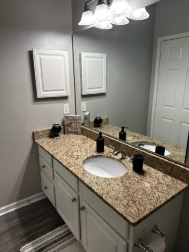 baño con lavabo y espejo grande en Extravagant 2 BR/2 BA Apartment en Savannah