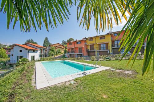 Cottage Del Lago - Happy Rentals في لافينو: مسبح في ساحة فيها مباني في الخلف