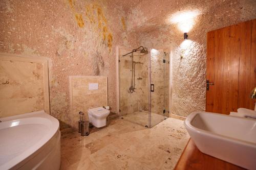 a bathroom with a shower and a toilet and a sink at Canyon Cave Hotel in Urgup