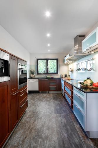 a large kitchen with wooden cabinets and a window at PRIMERA am See in Gaienhofen