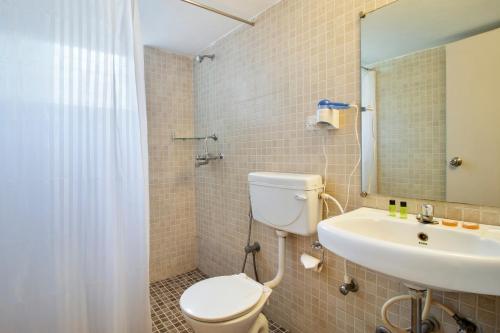 a bathroom with a toilet and a sink at Aldeia Santa Rita - Candolim in Candolim