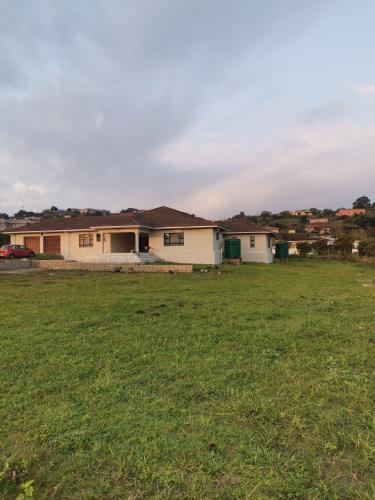 a house with a green field in front of it at Phakathi Lifestyle Village Umnini in Amanzimtoti