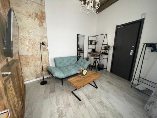 a living room with a blue couch and a table at Tomis’ Dreams in Constanţa