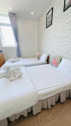 two beds sitting next to each other in a bedroom at Sele House in Ha Tien