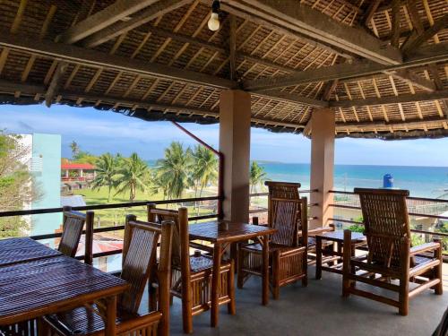 restauracja ze stołami i krzesłami oraz widokiem na ocean w obiekcie Anahaw Seaside Inn w mieście Wyspa Bantayan