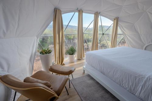 een slaapkamer met een bed en 2 stoelen voor een raam bij Skyview Hotel in Torrey